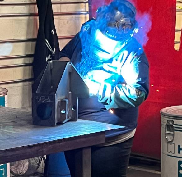 Skilled technician performing manual MIG hand welding. 